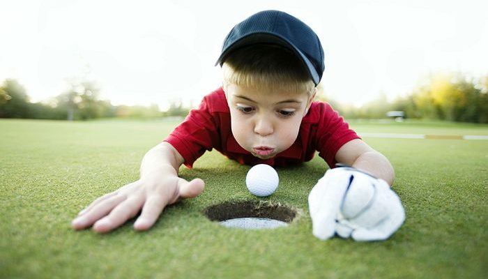 06_06_2024 Kid Blowing Golfball into hole.